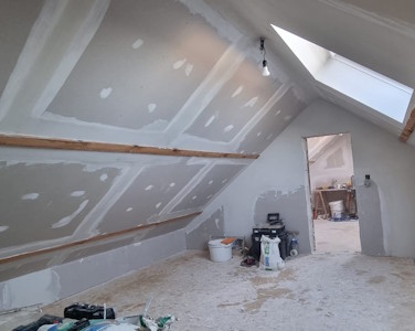 Aménagement d'un grenier à Liège - Début des enduits en versant de toiture et murs