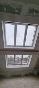 Aménagement d'un grenier à Beersel - Lumière apportée avec 2 chassis Velux 3en1 par temps couvert